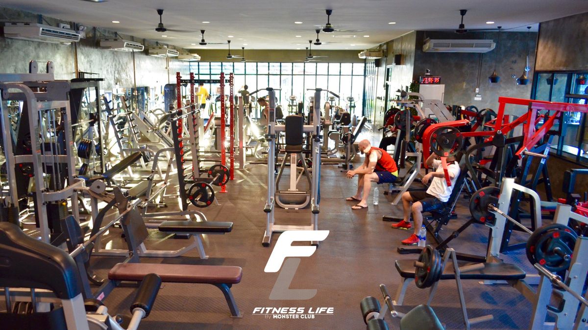 Members training on the main gym floor at Fitness Life Bangkok with weight machines and free weights